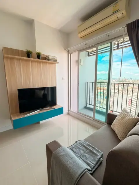 1 Bedroom Condo for Sale at Centric Sea living room with wall-mounted TV and balcony city view