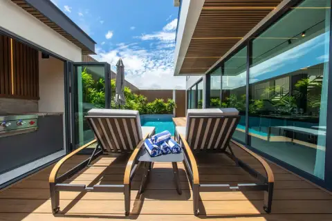 5 Bedroom House for Sale in Bang Lamung poolside terrace with sun loungers, rolled towels and glass wall overlooking pool