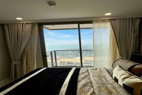 1 Bedroom Condo for Rent at Copacabana Beach Jomtien bedroom with double bed and floor-to-ceiling sea view window