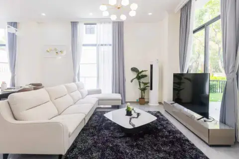 4 Bedroom House for Sale at Tadarawadi South Pattaya: Modern living room with a white sectional sofa and large TV.