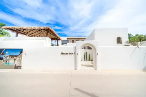 4 Bedroom House for Sale at The Sunshine House white-render exterior entrance gate with House No.1 sign and arched doorway with cacti