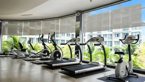 Dusit Grand Park 1 fitness center with treadmills and ellipticals facing garden view