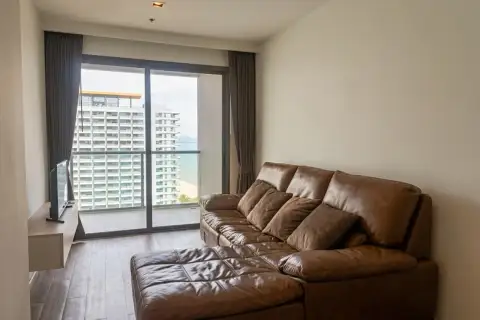 1 Bedroom Condo for Sale at Aeras living room with leather sofa and balcony sea view