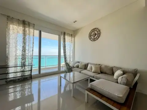 2 Bedroom Condo for Sale at Reflection Jomtien Beach living room with sofa and ocean view through glass doors