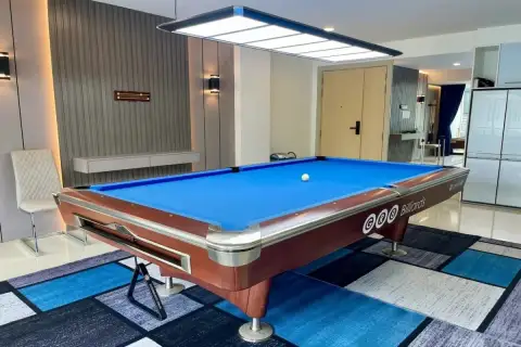 1 Bedroom Condo for Sale at Gardenia Pattaya GRB billiards table under pendant light with textured grey accent wall and mirrored panels