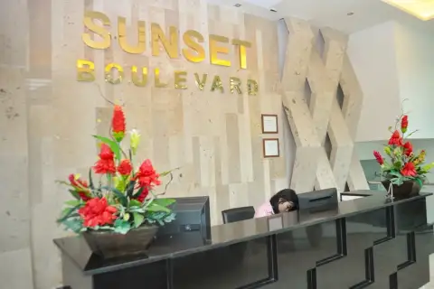 Sunset Boulevard Residence 1 lobby reception desk with illuminated signage and floral decor