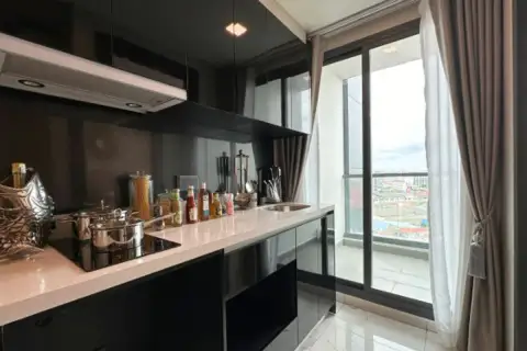 1 Bedroom Condo for Sale at Arcadia Millennium Tower lounge area with mounted TV, entry door, and marble coffee table