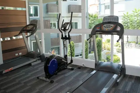 Apus fitness centre with treadmills and elliptical cross trainer machines beside floor-to-ceiling windows overlooking gardens