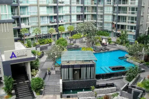 Apus condominium entrance sign with overhead view of courtyard pool, landscaped gardens and sun loungers