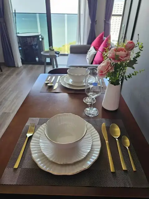 1 Bedroom Condo for Sale at Andromeda Condominium dining table set with sea view living area in background