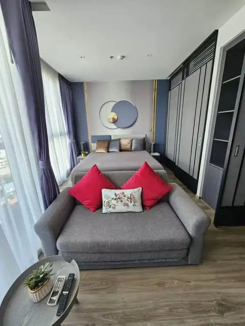 1 Bedroom Condo for Sale at Andromeda Condominium bedroom with gray bed, red cushions and sofa seating