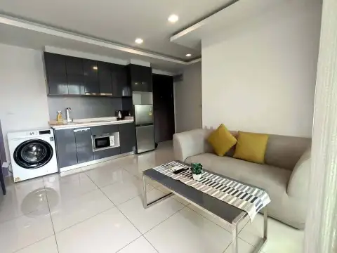 2 Bedroom Condo for Rent at Arcadia Beach Continental open kitchen with washing machine, fridge and sofa area