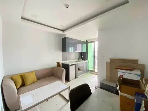 1 Bedroom Condo for Sale at Arcadia Beach Continental open-plan living area with kitchen cabinets and dining table