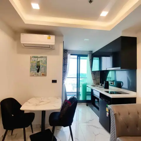 1 Bedroom Condo for Sale at Arcadia Millennium Tower dining area and black kitchenette with balcony overlooking the city