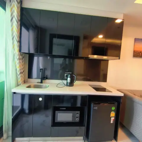 1 Bedroom Condo for Sale at Arcadia Millennium Tower compact kitchenette with microwave, mini fridge, and stovetop