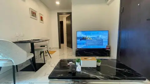 2 Bedroom Condo for Sale at Arcadia Millennium Tower dining area with marble coffee table and wall-mounted TV