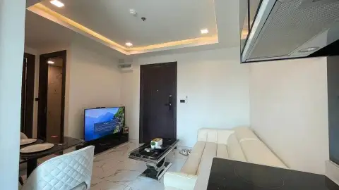 2 Bedroom Condo for Sale at Arcadia Millennium Tower open-plan living space with kitchen hood, entry door and sofa