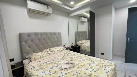 2 Bedroom Condo for Sale at Arcadia Millennium Tower bedroom with tufted headboard, mirrored closet and floral bedding
