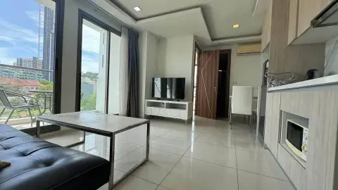 2 Bedroom Condo for Sale at Arcadia Beach Resort open-plan living area with kitchenette and balcony view