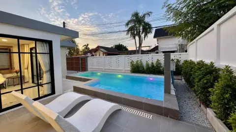 3 Bedroom House for Sale at Areeya Villa illuminated outdoor pool with garden and patio seating at twilight
