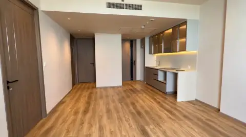 2 Bedroom Condo for Sale at Arom Jomtien open-plan living area with kitchen cabinets and wood flooring