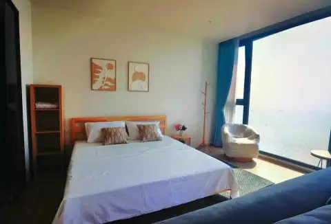 1 Bedroom Condo for Sale at Arom Wongamat bedroom with white bed and panoramic ocean view window