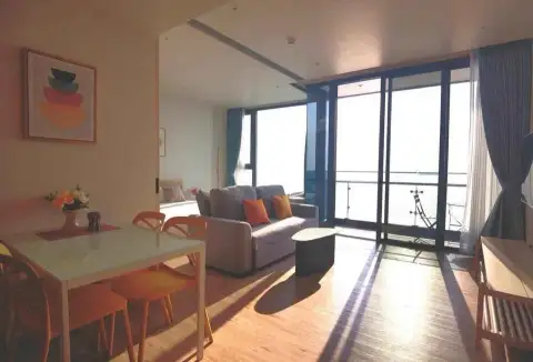 1 Bedroom Condo for Sale at Arom Wongamat living room with dining table, sofa and sea-view balcony