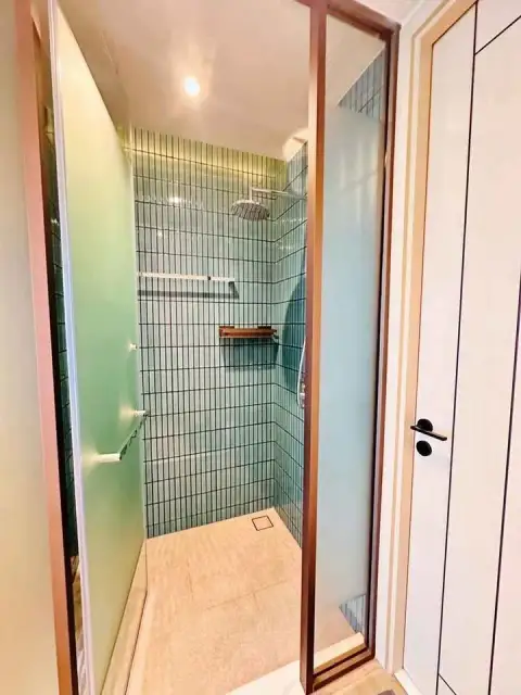 1 Bedroom Condo for Rent at Arom Wongamat glass-enclosed shower with teal tiled walls