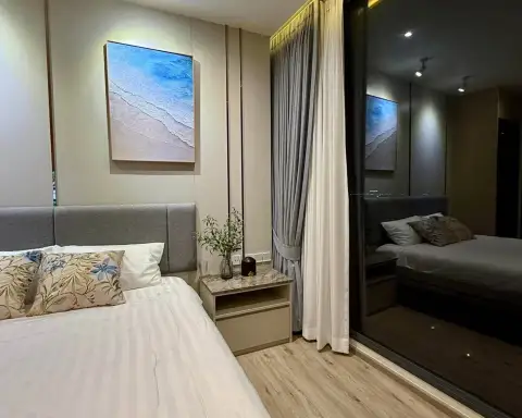 1 Bedroom Condo for Rent at Arom Wongamat bedroom with gray headboard, beach artwork, and mirrored closet