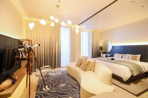1 Bedroom Condo for Sale at Arom Wongamat sitting area with decorative telescope, patterned rug and branch-style chandelier