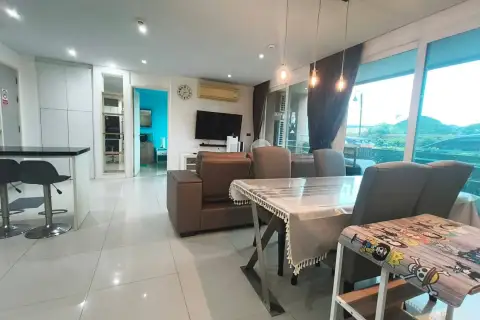 2 Bedroom Condo for Sale & Rent at Atlantis Condo Resort dining and living area with wall-mounted TV and balcony view