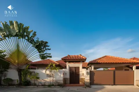 Baan Balina 3: Front view of the property entrance with a traditional wooden gate, fence, and palm trees.
