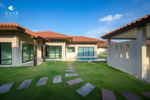 Baan Balina 3: Backyard view of the house with a small pool, green grass, and stepping stones.