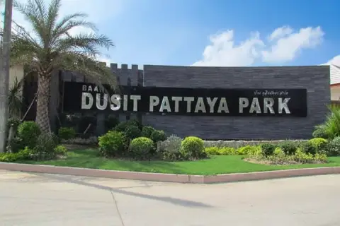 Baan Dusit Pattaya Park aerial view showing numerous houses, a large swimming pool with slides, and green landscape.