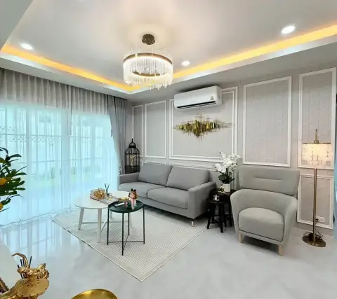 4 Bedroom House for Sale at Baan Pruksa Nara Chaiyapruek elegant living room with crystal chandelier and gray sofa