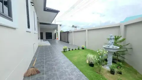 3 Bedroom House for Sale in Bang Sare featuring side garden walkway with fountain and tiled pathway