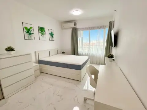 1 Bedroom Condo for Sale at Supalai Mare Pattaya bedroom with white desk chair and sheer curtained window