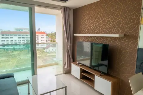 1 Bedroom Condo for Sale at Amazon Residence TV wall with wood cabinet and balcony view of Pattaya