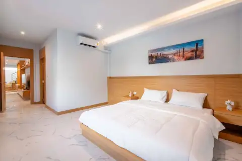 4 Bedroom House for Rent in Central Pattaya spacious master bedroom with marble floor and coastal wall art