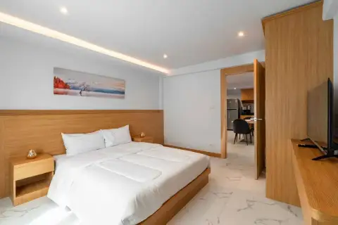 4 Bedroom House for Rent in Central Pattaya bedroom with wooden headboard and view to kitchen area
