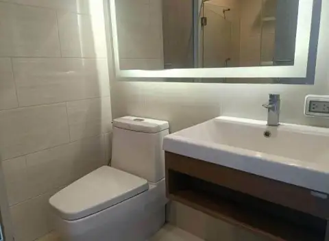 1 Bedroom Condo for Sale at Cetus Beachfront bathroom with toilet, vanity sink and backlit mirror