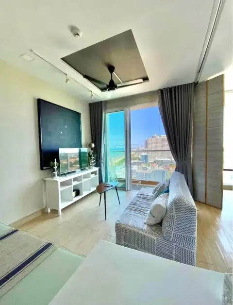 1 Bedroom Condo for Sale at Cetus Beachfront living room with sofa, TV, and sea view balcony