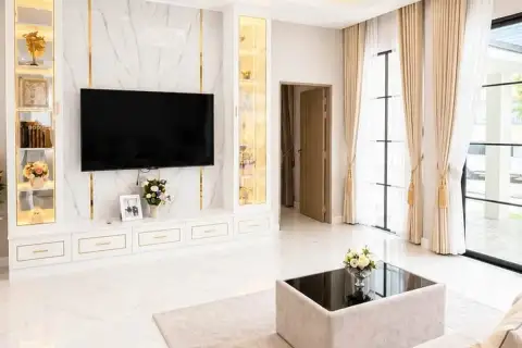 4 Bedroom House for Sale at Chokchai Garden Home 2, living room with a large L-shaped sofa, coffee table, and dining area.