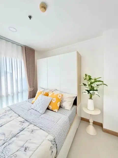 1 Bedroom Condo for Sale at City Center Residence cozy bedroom with yellow floral pillows and potted plant