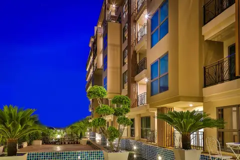 City Garden Tropicana outdoor swimming pool with wooden loungers and poolside condo balconies