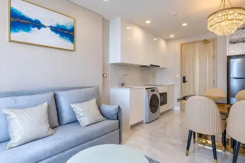 1 Bedroom Condo for Sale at Copacabana Beach Jomtien open-plan kitchen with dining table and crystal chandelier