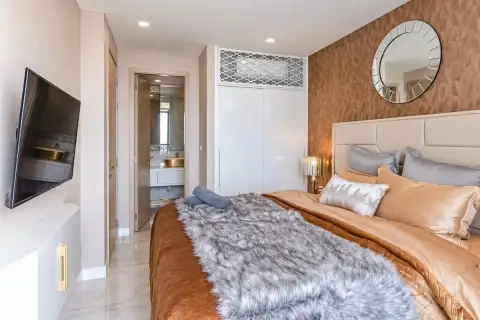 1 Bedroom Condo for Sale at Copacabana Beach Jomtien bedroom with fur throw, round mirror and wall-mounted TV