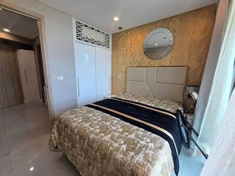 1 Bedroom Condo for Rent at Copacabana Beach Jomtien bedroom with upholstered headboard and round mirror
