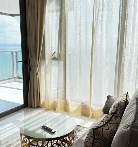 2 Bedroom Condo for Rent at Copacabana Beach Jomtien balcony seating area with sheer curtains and sea view