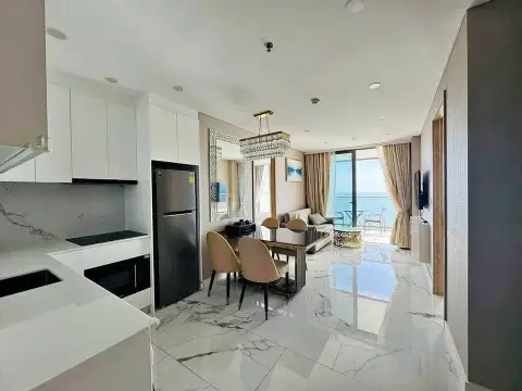 2 Bedroom Condo for Sale at Copacabana Beach Jomtien open-plan kitchen with black fridge and marble flooring overlooking living room